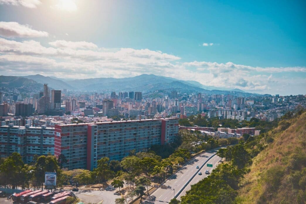 An aerial view of Avenida Boyacá (Cota Mil) in Caracas, Venezuela, with an urban sprawl leading to mountains in the distance