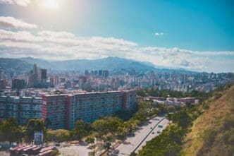 An aerial view of Avenida Boyacá (Cota Mil) in Caracas, Venezuela, with an urban sprawl leading to mountains in the distance