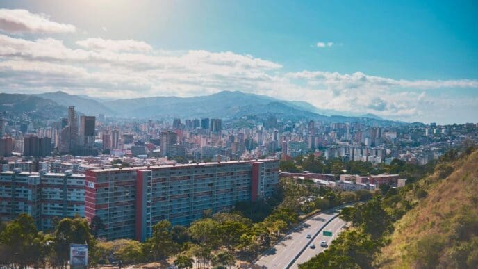 An aerial view of Avenida Boyacá (Cota Mil) in Caracas, Venezuela, with an urban sprawl leading to mountains in the distance