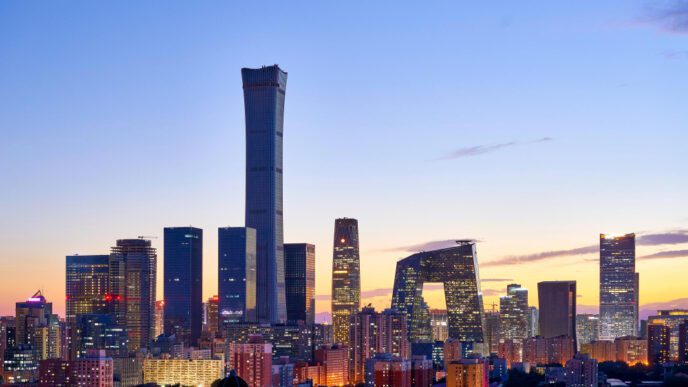 The Beijing skyline at dusk with modern, illuminated skyscrapers against a twilight sky