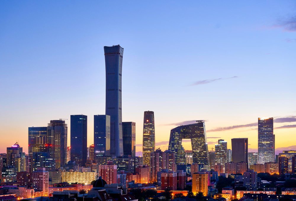 The Beijing skyline at dusk with modern, illuminated skyscrapers against a twilight sky