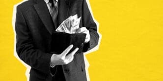 Man in suit putting US dollars into a wallet