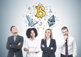 Four diverse businesspeople looking up at a drawing of a Bitcoin and other cryptocurrencies