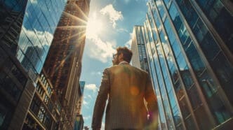 A man looks up at skyscrapers, symbolizing ambition and success