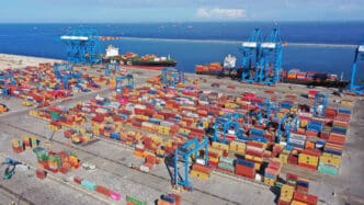 Aerial view of a busy container port in Ghana with ships and cranes