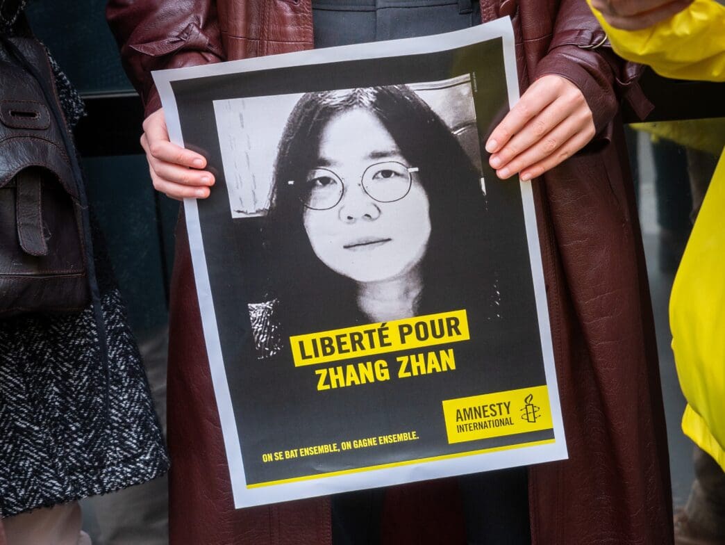 A poster calling for "Liberté pour Zhang Zhan" (Freedom for Zhang Zhan) is held up