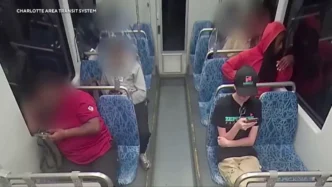 A CCTV still from a Charlotte Area Transit System train shows passengers seated, with their faces blurred