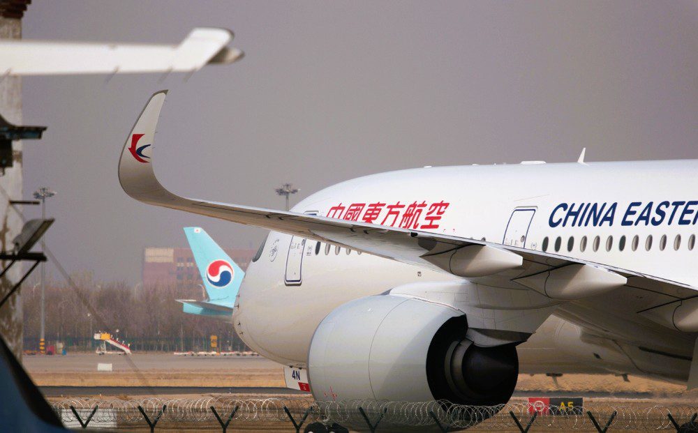 A China Eastern Airlines passenger plane is parked on an airport tarmac with another plane behind it