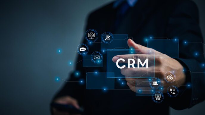 A person in a suit points to the glowing letters "CRM" surrounded by digital icons