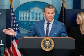 Defense Secretary Pete Hegseth speaks at a press conference from a podium with a serious expression