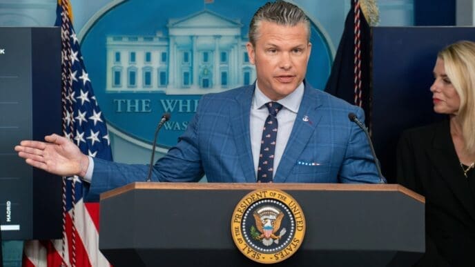Defense Secretary Pete Hegseth speaks at a press conference from a podium with a serious expression