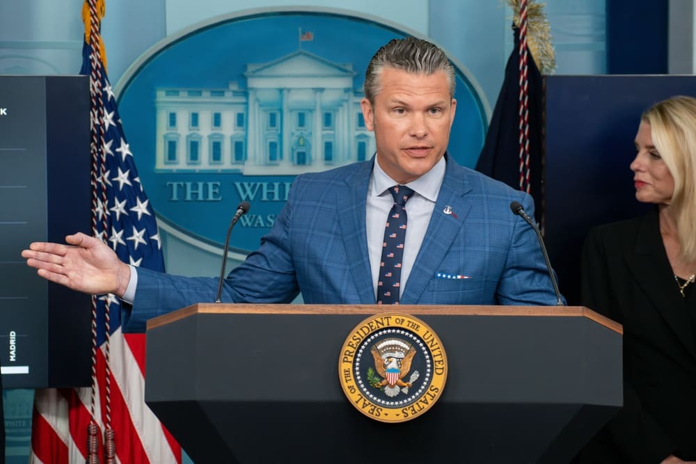 Defense Secretary Pete Hegseth speaks at a press conference from a podium with a serious expression