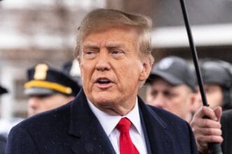 Donald Trump Jr. speaking with an open mouth and a red tie