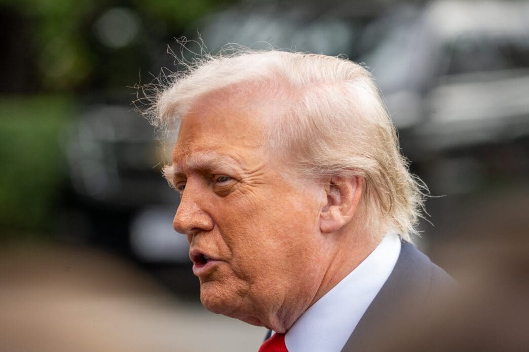 Close-up of Donald Trump speaking outdoors, with his hair blowing in the wind