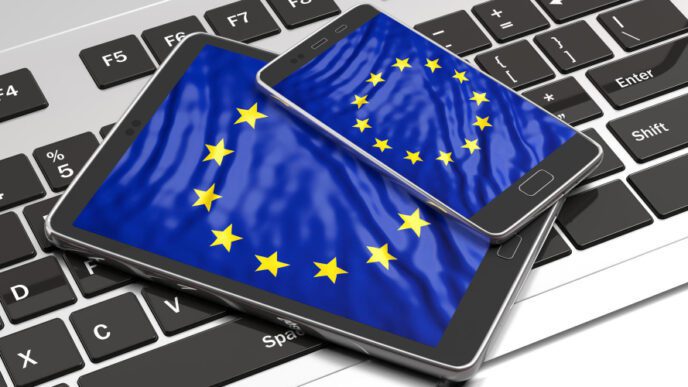 A tablet and a smartphone with the EU flag displayed on their screens, resting on a laptop keyboard