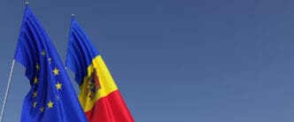 The flags of the European Union and Moldova displayed together against a blue sky