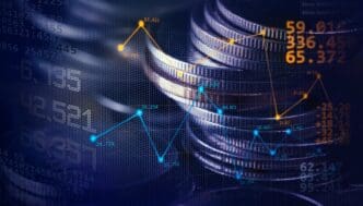 A double-exposure image combines a stack of coins with a digital financial graph and data, representing economic trends