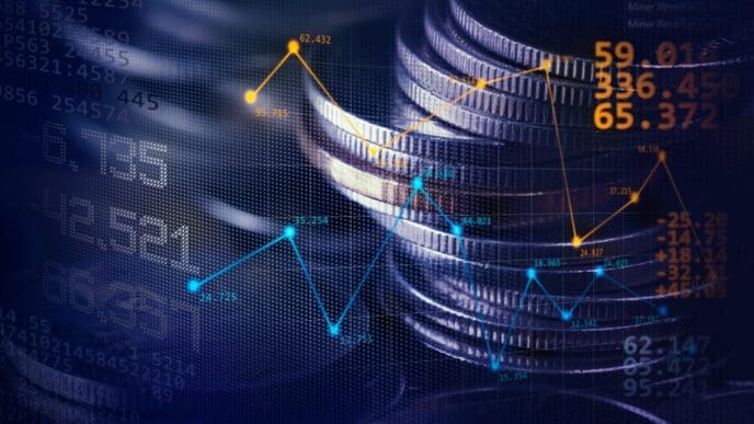 A double-exposure image combines a stack of coins with a digital financial graph and data, representing economic trends