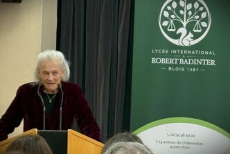 The philosopher Elisabeth Badinter speaking at a podium at the inauguration of a high school