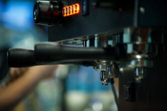 Close-up of an espresso machine with glowing red indicator lights