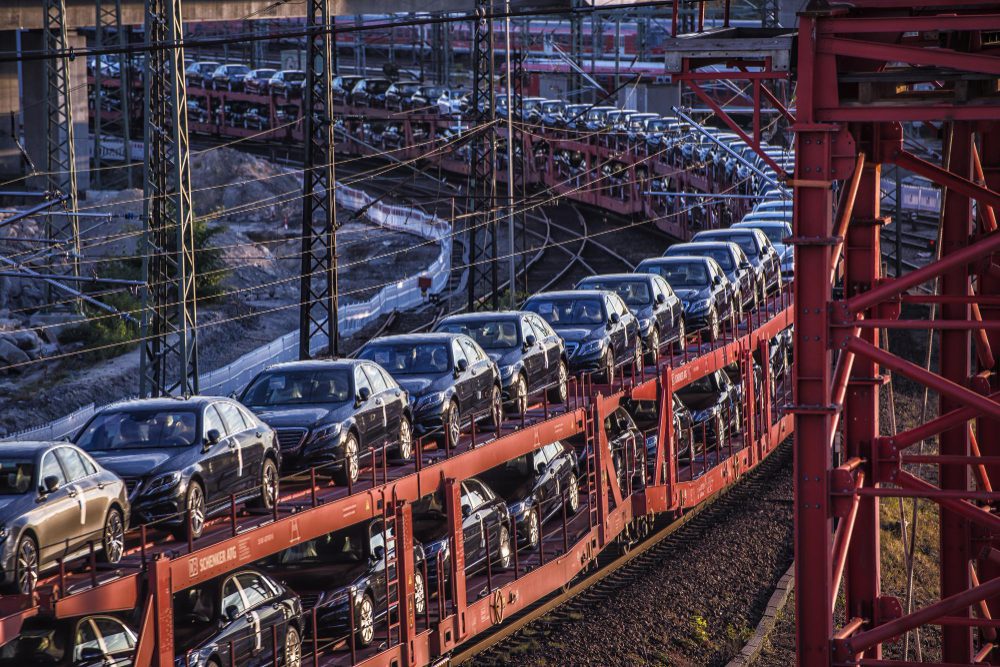 New European cars are loaded onto a long freight train for transportation and export