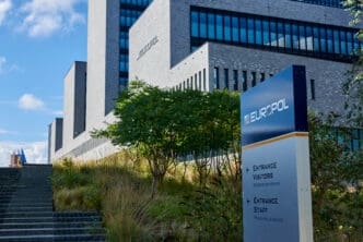 The Europol headquarters building with a sign indicating entrances for visitors and staff
