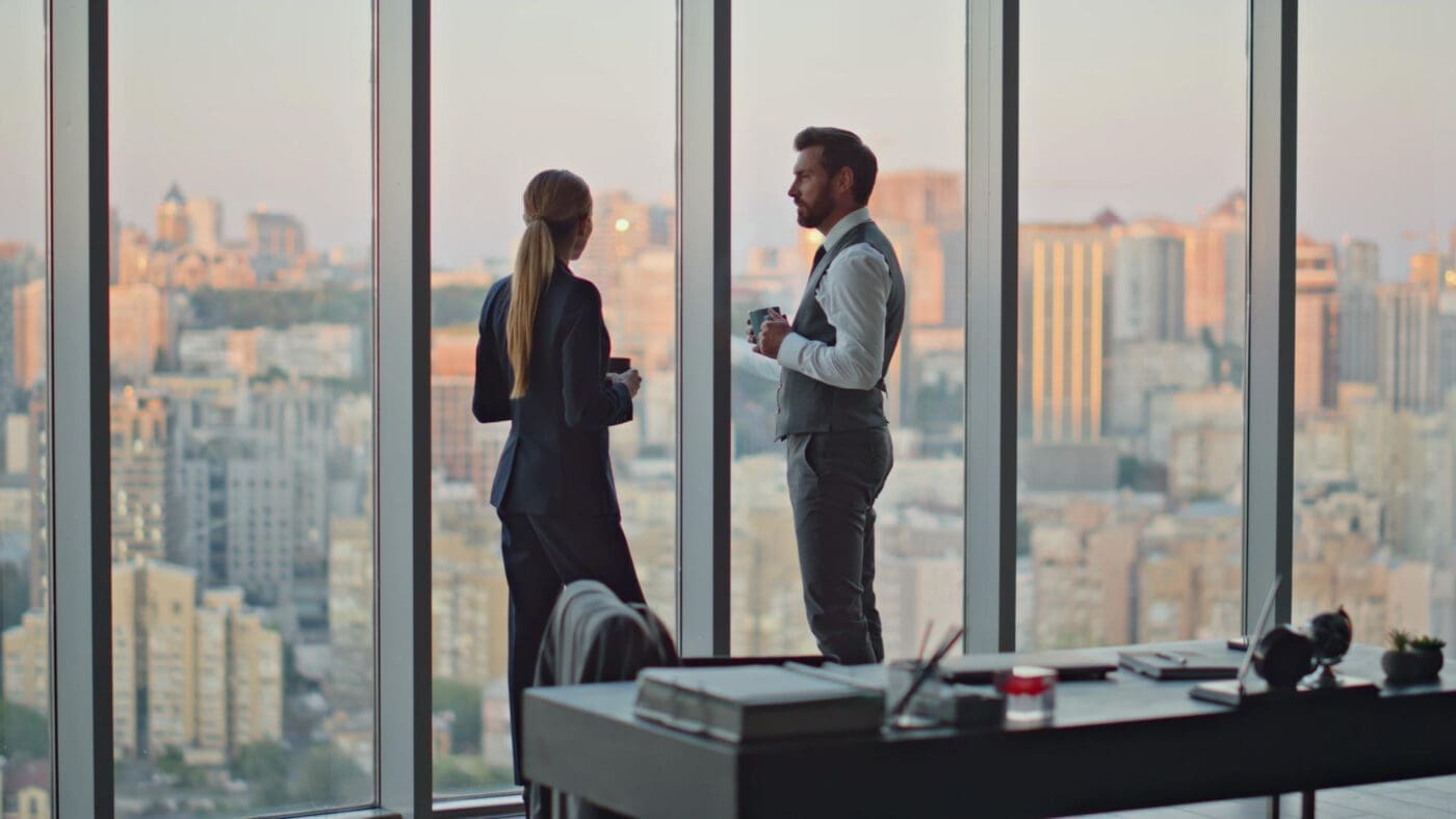 Business professionals in a high-rise office overlooking a city skyline