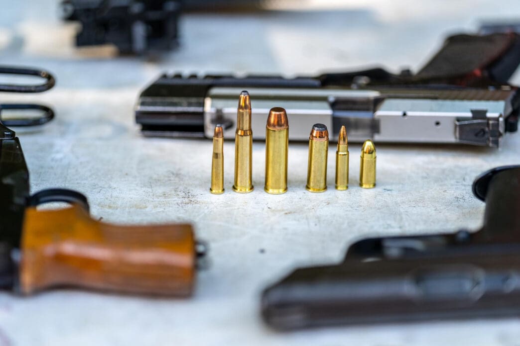 A collection of firearms and ammunition displayed on a table
