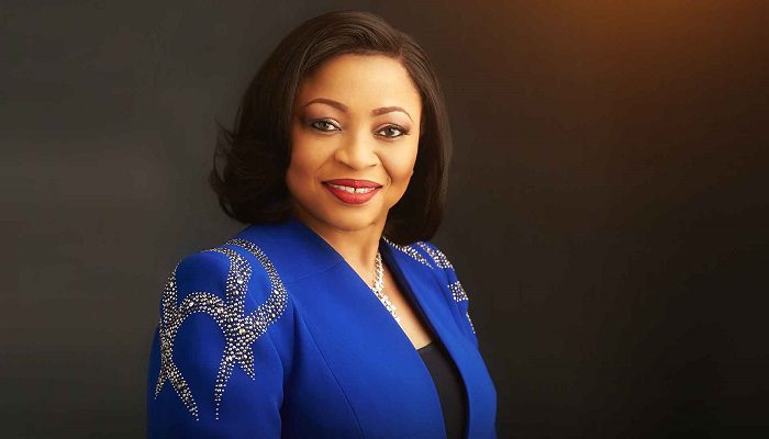 Folorunsho Alakija, a woman with a confident smile, wears a blue jacket with a studded pattern