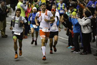 French trail runner François d'Haene jogs toward the camera with other runners behind him