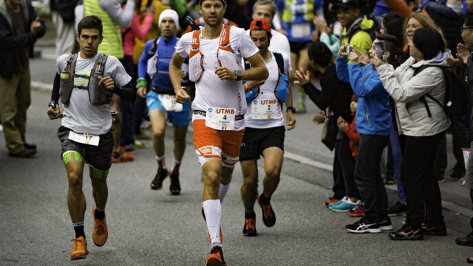 French trail runner François d'Haene jogs toward the camera with other runners behind him
