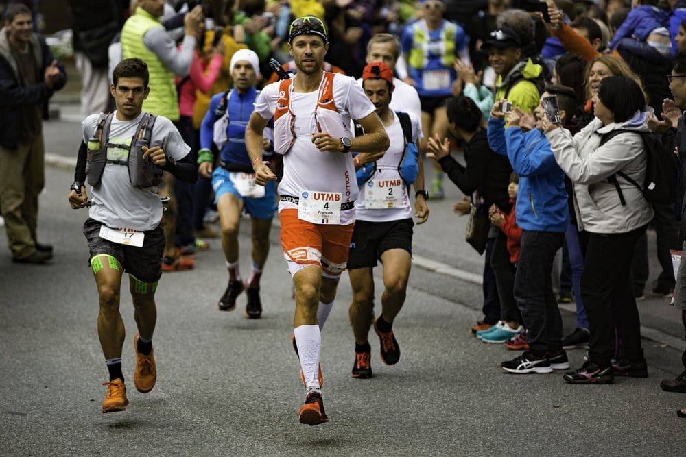 French trail runner François d'Haene jogs toward the camera with other runners behind him