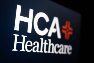 The HCA Healthcare logo with a white cross and the company name on a computer screen