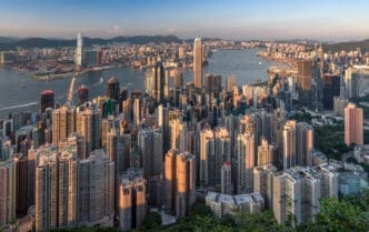 Panoramic view of Hong Kong's dense cityscape and Victoria Harbour at sunset