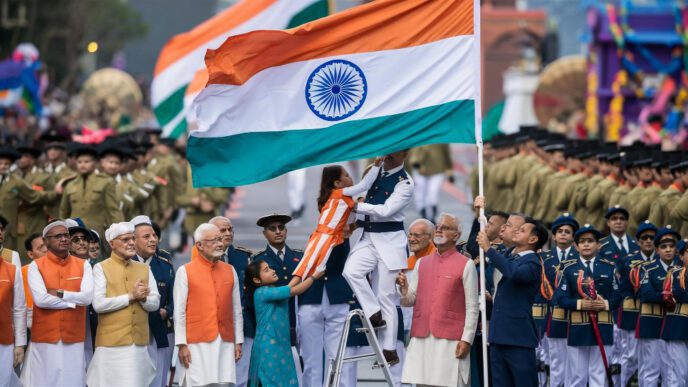 A large Indian flag being held by a group of people, including children and military personnel