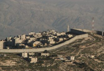 The Israeli West Bank barrier, a large concrete wall, separates a Palestinian town from the surrounding land