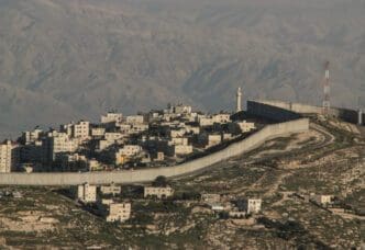 The Israeli West Bank barrier, a large concrete wall, separates a Palestinian town from the surrounding land