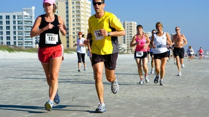 A group of runners competes in the Jacksonville Beach 10-mile beach run on a sunny day in Florida