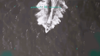 An overhead aerial view shows a white vessel speeding across the water, leaving a large white wake behind it