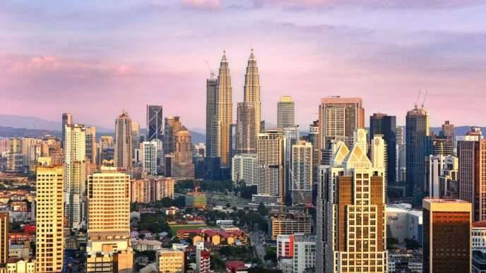 The panoramic skyline of Kuala Lumpur with the iconic Petronas Towers at sunset