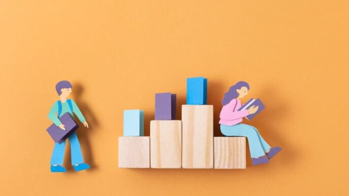 Paper cutouts of two people and wooden blocks form a conceptual image about education and the labor market
