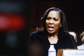 American economist Lisa Cook speaks passionately into a microphone at a formal event