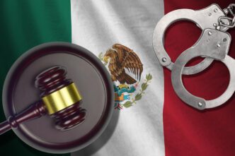 A gavel and handcuffs are shown over a Mexican flag, symbolizing law and justice