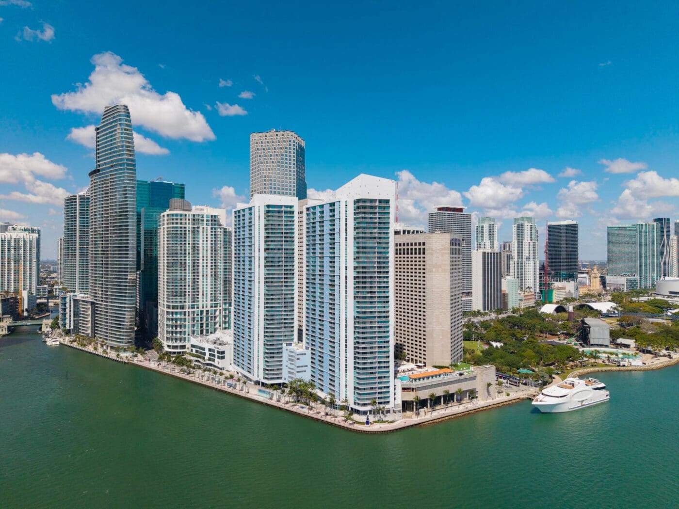 An aerial view of Miami's downtown skyline and waterfront with a modern yacht