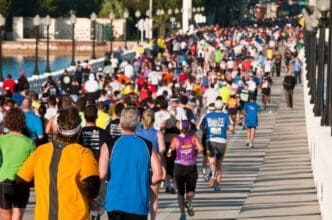 Hundreds of runners in colorful shirts crowd a bridge during a marathon race
