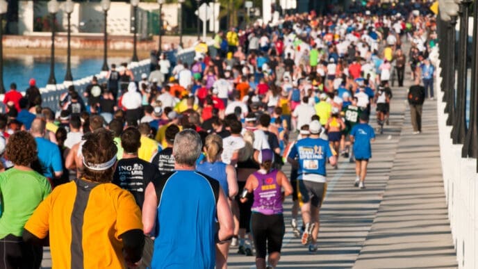 Hundreds of runners in colorful shirts crowd a bridge during a marathon race