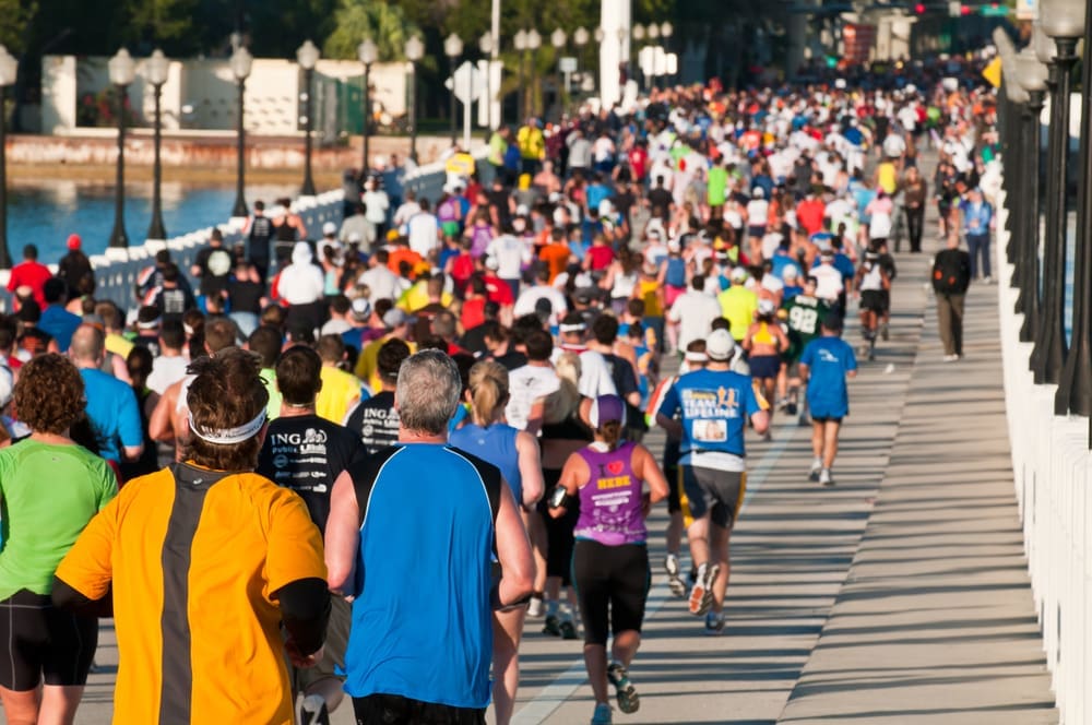 Hundreds of runners in colorful shirts crowd a bridge during a marathon race