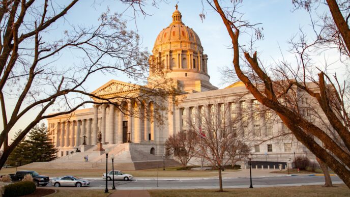 The Missouri State Capitol building is shown with a grand dome on a late afternoon