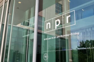 The NPR logo and operating hours displayed on a glass door