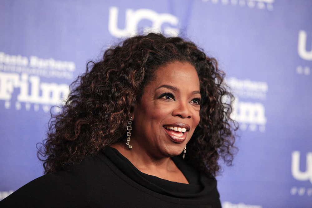 Oprah Winfrey with her hair styled in voluminous curls and a wide smile